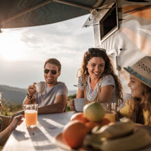 Happy parents and their small kids communicating while spending a spring day on camping. Focus is on man. Copy space.